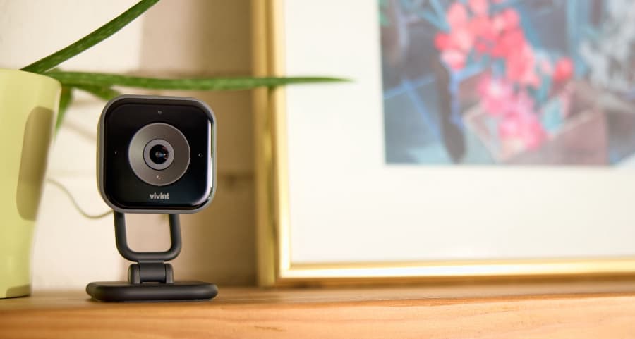 Vivint interior camera installed on a mantel beside a picture